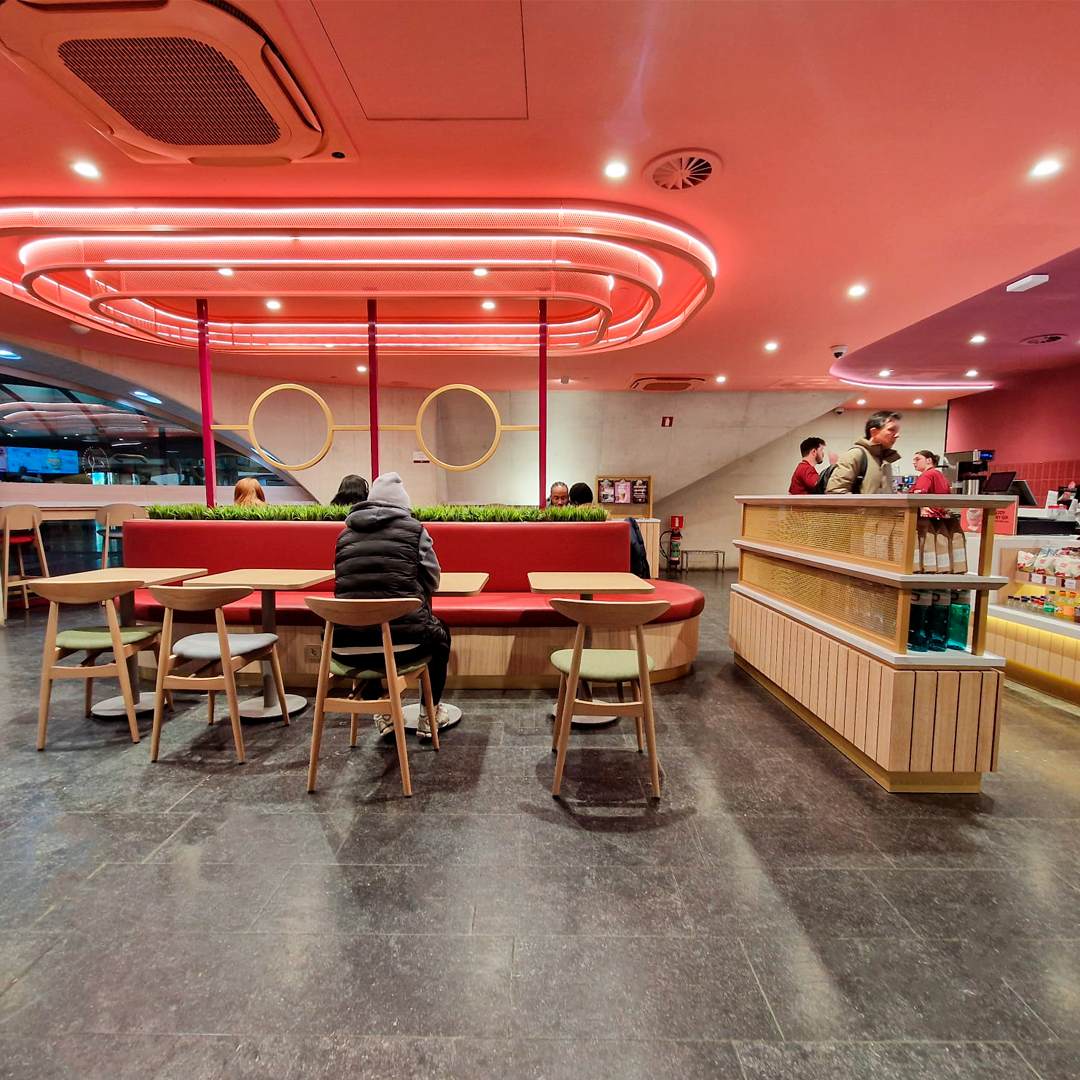 Interior moderno de restaurante de comida rápida con iluminación roja.