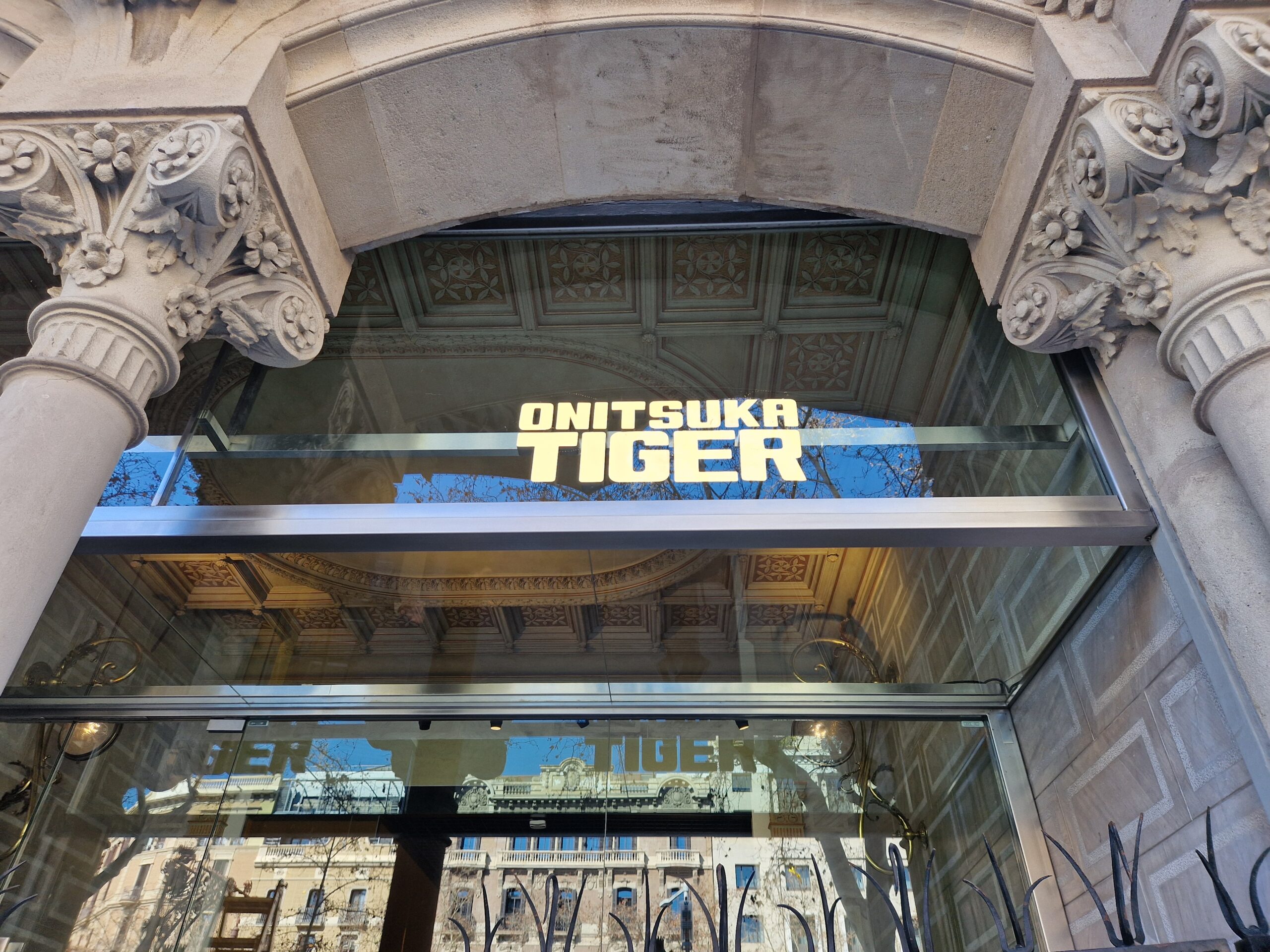 Entrada tienda Onitsuka Tiger con fachada ornamentada.
