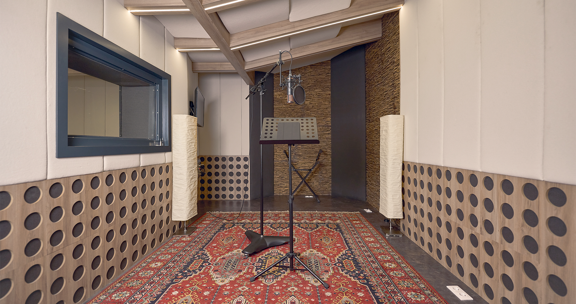 Estudio de grabación profesional con micrófono y cabina vocal.