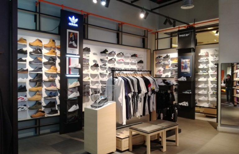 Tienda Adidas con zapatillas y ropa deportiva en exhibición.