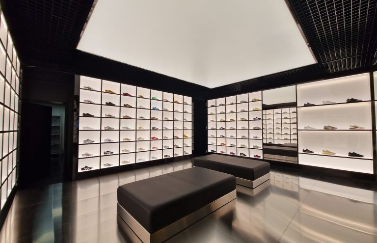 Interior de tienda moderna con gran exhibición de zapatillas.