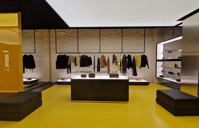 Interior moderno de tienda de ropa con exhibición de bolsos.