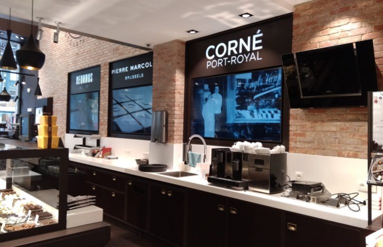 Mostrador de pastelería con máquinas de café y decoración moderna.