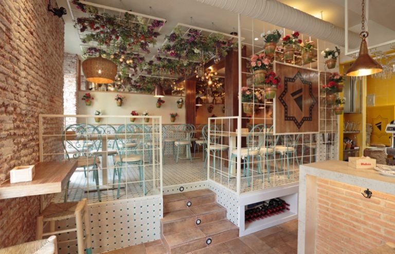 Interior de restaurante con decoración floral y ambiente acogedor.