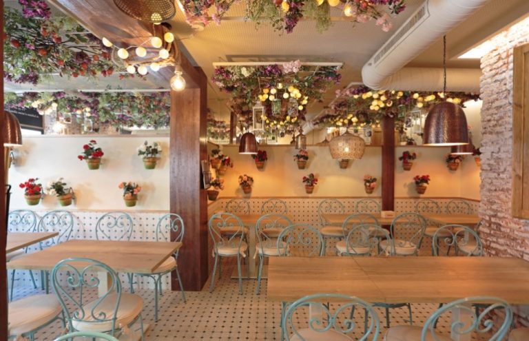 Interior de restaurante decorado con flores y luces cálidas.